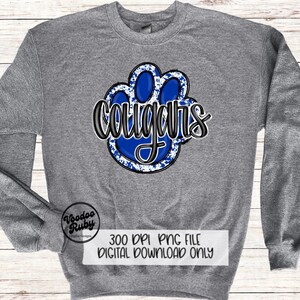 May include: A gray sweatshirt with a blue paw print design and the word "cougars" in black lettering. The paw print has a white splatter effect.