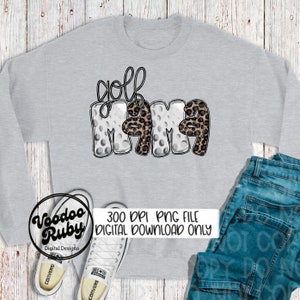 May include: A gray sweatshirt with the text "golf mama" in white and black letters. The letters are decorated with a golf ball pattern and leopard print.