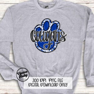 May include: A gray sweatshirt with a blue paw print graphic and the word "Cougar's" in black lettering. The paw print has a white splatter design.