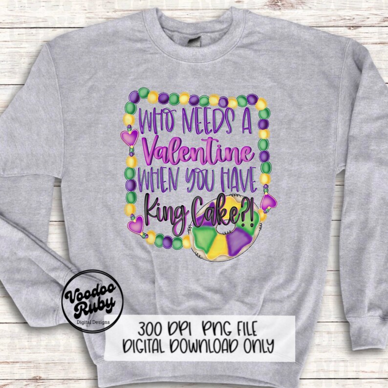 May include: A light gray crewneck sweatshirt featuring a graphic print of purple, green, and yellow Mardi Gras beads forming a square frame around the text "WHO NEEDS A VALENTINE WHEN YOU HAVE KING CAKE?!" and a colorful king cake illustration.