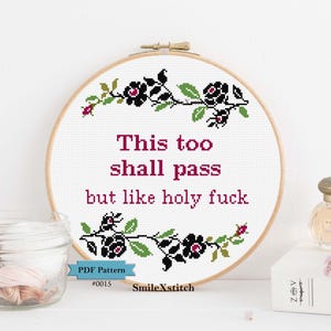 Könnte beinhalten: Ein Kreuzstich-Stickrahmen mit dem Text "This too shall pass but like holy fuck" in Burgunderrot. Das Design umfasst schwarze Blumen und grüne Blätter. Das PDF-Muster ist mit #0015 gekennzeichnet und stammt von SmileXstitch.