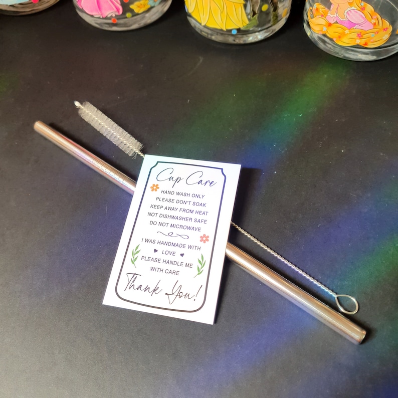 May include: A white card with the text "Cup Care" and instructions for hand washing, soaking, heat, dishwasher, and microwave use. The card also includes the text "I was handmade with love. Please handle me with care. Thank You!"  A stainless steel straw and a cleaning brush are also pictured.