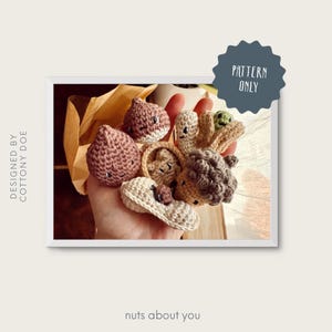 Op de afbeelding: Een verzameling handgemaakte gehaakte noten in verschillende kleuren en ontwerpen, waaronder eikels en pinda's. De afbeelding bevat de tekst "PATTERN ONLY" en "nuts about you". Het ontwerp is van Cottony Doe.
