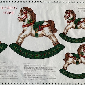 May include: A white fabric panel with instructions for making a rocking horse. The panel features a repeated pattern of rocking horses with green and red accents. The text "ROCKING HORSE" is printed in black at the top of the panel.