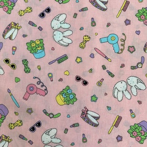 May include: A pink fabric with a repeating pattern of various objects, including a hairdryer, sunglasses, a potted plant, a pair of bunny ears, a watch, a bow, a star, a heart, and a makeup brush.
