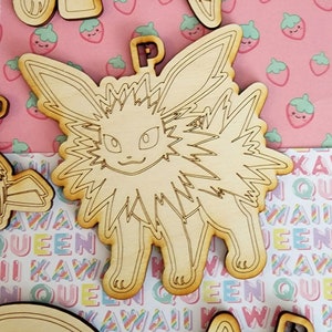 Puede incluir: Un conjunto de cinco adornos de madera sin terminar con diferentes personajes de Pokemon. Los adornos están recortados en forma de Pokemon y están listos para ser pintados.