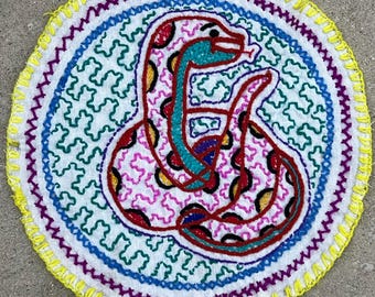 Shipibo 27 cm rund altarduk, Ayahuasca ormtapet, handbroderad mantaduk, shamanistisk ceremonitextil, växtmedicinlapp
