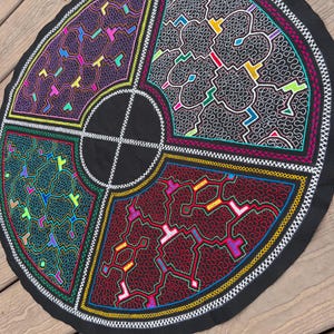 May include: A circular black fabric piece divided into four quadrants by white embroidered lines. Each quadrant features intricate, dense, maze-like embroidery in contrasting colors including purple, grey, green, and deep red with neon accents.