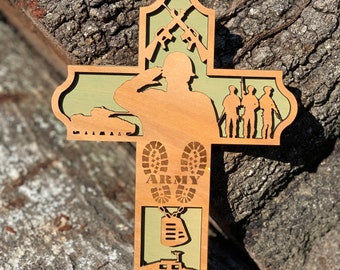 Pode incluir: Uma cruz de madeira com fundo verde. A cruz apresenta a silhueta de um soldado a saudar, um tanque, botas com a palavra "ARMY" nelas, uma identificação e um jipe.