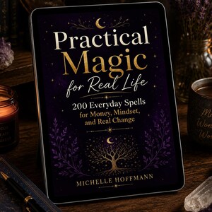 May include: A digital tablet displaying the book cover for Practical Magic for Real Life by Michelle Hoffmann. The cover features a dark purple background with gold text, a crescent moon, stars, and a tree illustration at the bottom.