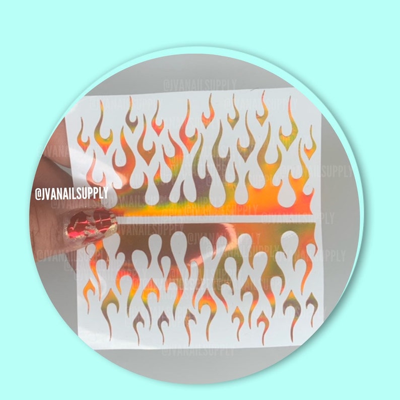 May include: Two sheets of white nail art stencils with a repeating pattern of flame shapes. The stencils are on a holographic background with orange, yellow, and pink colors.