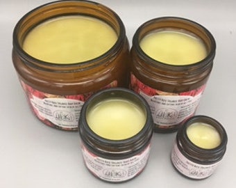 May include: Four amber glass jars of different sizes filled with a pale yellow balm. The jars have a floral design with the text "All Things Kind" on the label.