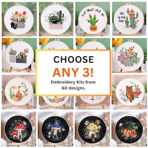May include: A collection of circular embroidery kits featuring various designs including cats, cacti, succulents, owls, and mushrooms. The central text reads CHOOSE ANY 3! Embroidery Kits from 60 designs. Each kit is mounted on a wooden hoop stand.
