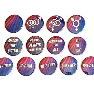 May include: A collection of round buttons with a blue, purple, and pink zebra stripe pattern. Some buttons feature white gender symbols, while others display phrases like "Smash the Cistem" and pronouns such as "They/Them."