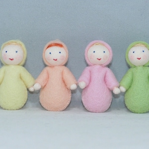 Puede incluir: Seis mu&ntilde;ecas de fieltro de diferentes colores, incluyendo blanco, amarillo, rosa, melocot&oacute;n, verde y azul. Cada mu&ntilde;eca tiene una cara simple con ojos bordados y una sonrisa.