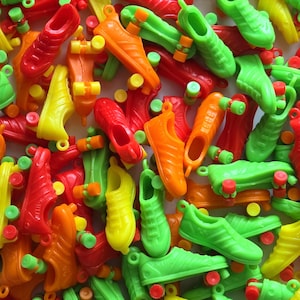 May include: A large group of colorful plastic roller skate charms in red, orange, yellow, and green. The charms are shaped like sneakers with wheels on the bottom.