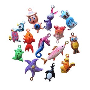 May include: A collection of small, colorful metal charms featuring various animal and character shapes, including a seahorse, owl, squirrel, penguin, frog, fish, rabbit, and cat, each with a small loop at the top for attachment to jewelry or crafts.