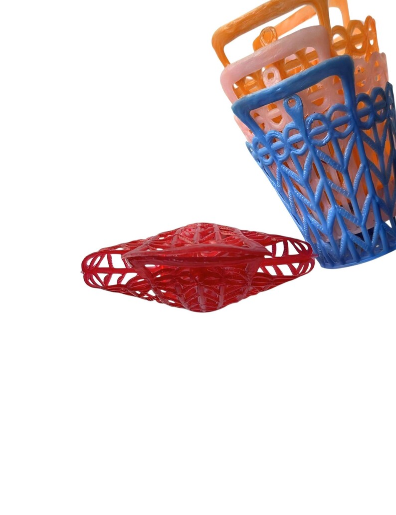 May include: A selection of colourful plastic baskets in red, blue, orange, and pink. The baskets feature a lattice design and handles. The red basket is flat, while the others are stacked.