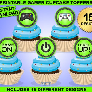 Op de afbeelding: Printbare cupcake-toppers met een gamer-thema. De toppers bevatten afbeeldingen van gamecontrollers, een aan/uit-knop en de woorden "Game On!" en "Level Up!" in groen en zwart. Er zijn 15 verschillende ontwerpen inbegrepen.