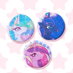 Puede incluir: Tres chapas circulares con ilustraciones estilizadas de criaturas equinas míticas. Una chapa muestra un personaje blanco con crines verde azulado, otra un personaje azul oscuro y la tercera un personaje rosa con crines moradas.