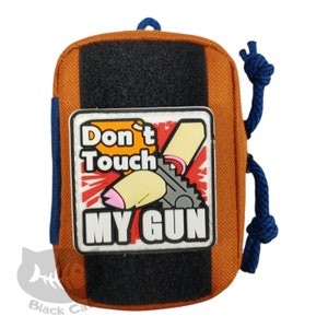 May include: Orange tactical pouch with a black velcro patch and a blue drawstring. The pouch features a patch with the text "Don't Touch MY GUN" and a cartoon gun graphic.