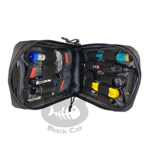 May include: Open black zippered pouch with various tools and accessories. The interior features multiple compartments and elastic straps holding items like flashlights, pens, and other small tools. The pouch is open, revealing its contents.