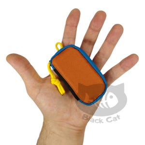 May include: A small, orange, zippered pouch with a black zipper and a blue trim. The pouch has a yellow cord attached to it.
