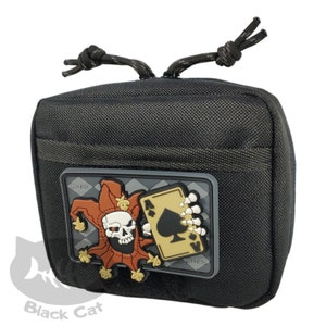 May include: Black tactical pouch with a patch featuring a skull-faced jester holding the Ace of Spades card. The patch has a gray and gold color scheme. The pouch has a small pocket on the front and a drawstring closure.