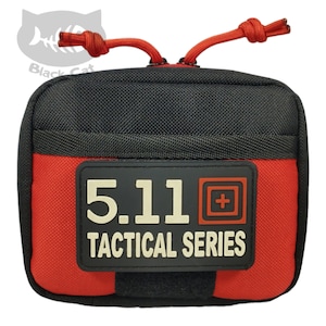 May include: A small, red and black zippered pouch with a 5.11 Tactical Series patch. The pouch has a black zipper pull with a red cord.
