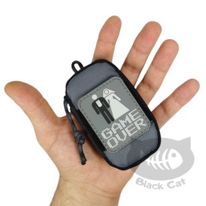 May include: A gray zippered pouch with a black patch that says "GAME OVER" and a white graphic of a bride and groom.