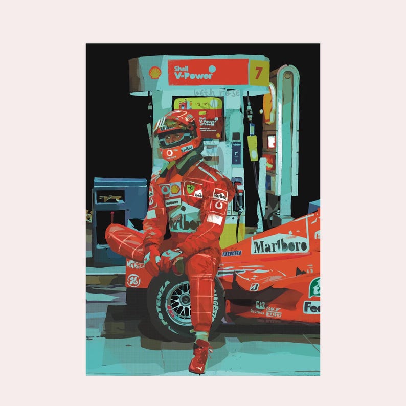 May include: A red race car with a red and white driver sitting next to it. The car has a Marlboro logo on the side. The driver is wearing a helmet and a red racing suit. The car is parked next to a gas station.