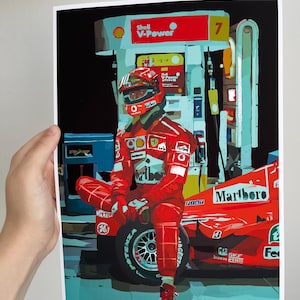 May include: A red Formula One race car with a driver wearing a red racing suit and helmet. The car is parked at a gas station with a Shell V-Power sign. The car has a Marlboro logo on the side.