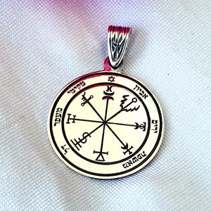 Può includere: Ciondolo in argento con un design circolare che presenta una stella di David, una croce e altri simboli. Il ciondolo è inciso con testo ebraico.