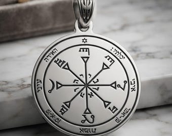 May include: A circular silver pendant featuring an intricate eight-pointed star design with engraved Hebrew characters and symbols. The pendant has a polished metallic finish with dark recessed lines, a small star at the top, and a decorative bail.