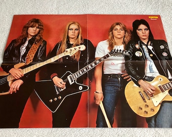 May include: A poster featuring a band of four women playing electric guitars. The women are wearing leather jackets and jeans. The poster has a red background and the word "POSTER" is printed in yellow at the top.