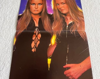 May include: A poster featuring two women with long blonde hair wearing black leather jackets. The poster has the text "POSTER Lita Ford Vicky Blue" at the bottom.