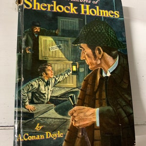 May include: Vintage hardcover book titled "Adventures of Sherlock Holmes" by A. Conan Doyle. The cover features an illustration of Sherlock Holmes and other characters in a detective scene, with a dark, mysterious background.