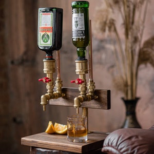 Dispenser for alcohol and non-alcoholic beverages for two bottles, made of brass plumbing pipes, bronze-colored pipes, on a wooden stand