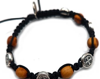 Peut inclure: Bracelet en cordon noir orné de perles en bois et d'éléments métalliques argentés. Le bracelet comprend des perles rondes en bois et des breloques métalliques circulaires avec des symboles religieux. La conception est réglable.