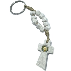 May include: White stone rosary keychain with a silver key ring and a cross pendant featuring a small image of the Virgin Mary.