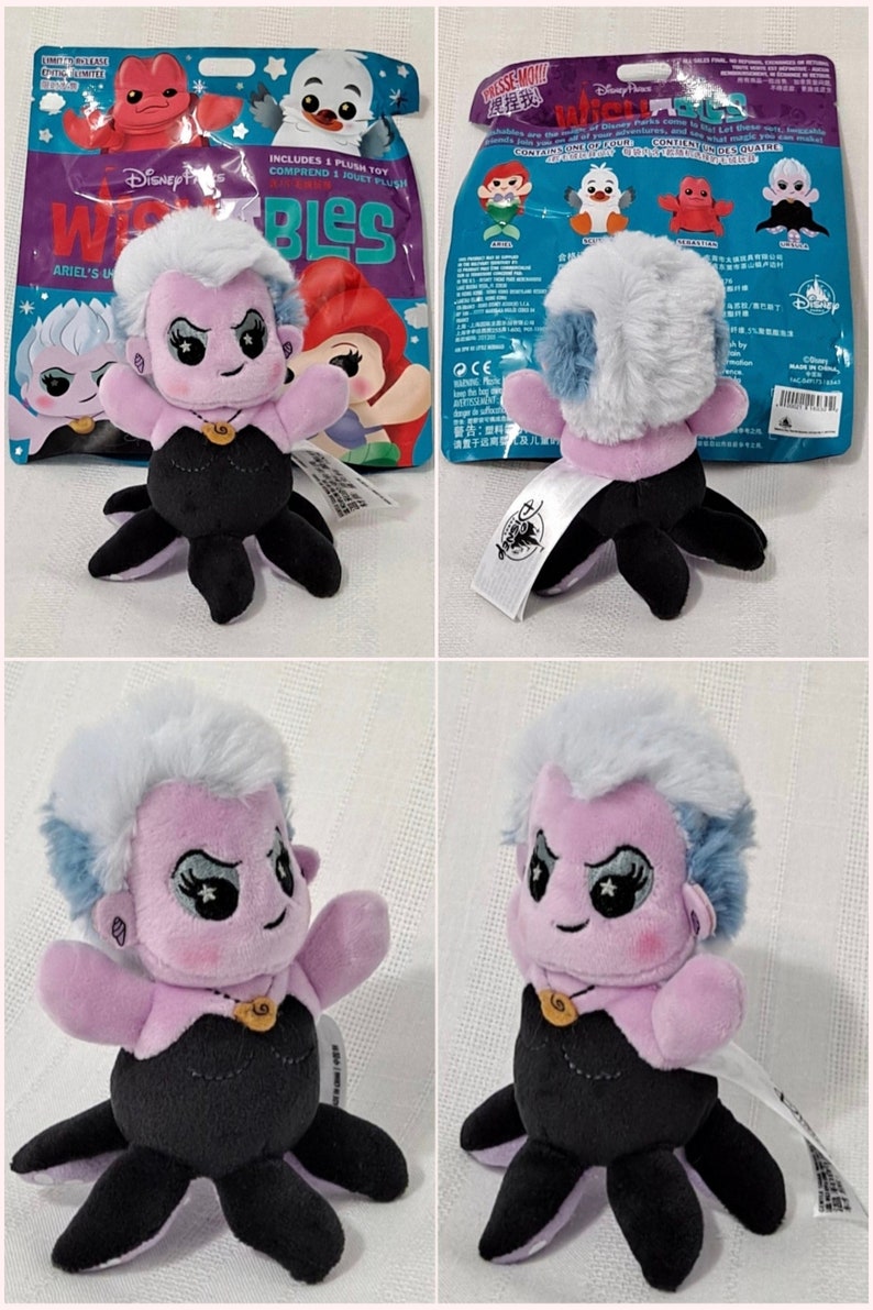 May include: A purple and blue Ursula plush toy from Disney's The Little Mermaid. The plush toy is wearing a black dress and has a purple shell necklace. The toy is part of a Disney Parks exclusive collection called "Wishables".