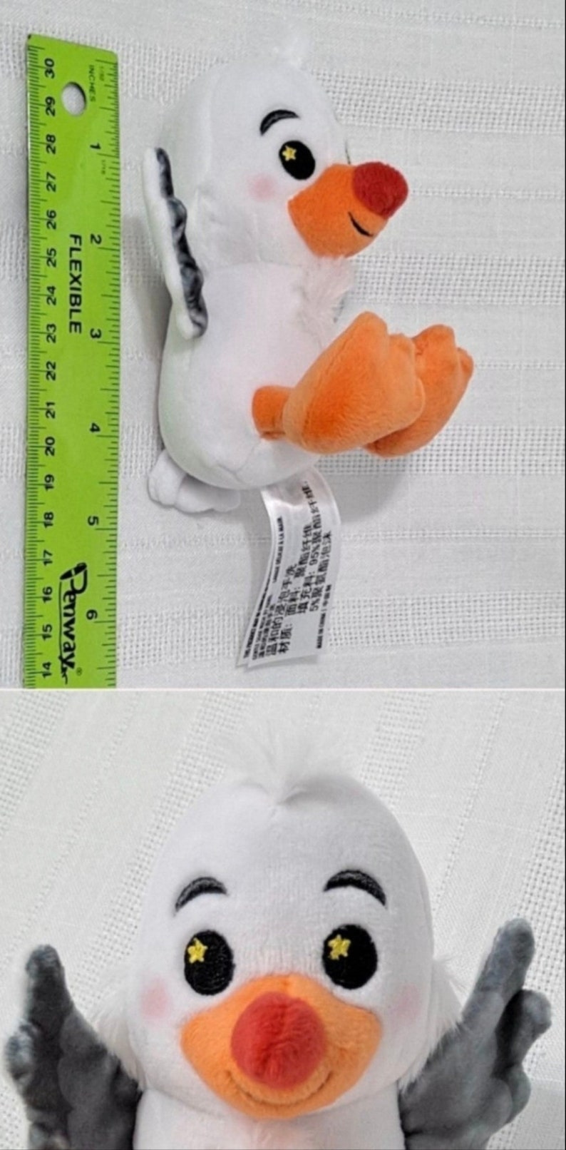 May include: White plush toy of a seagull with orange beak and feet. The seagull has black eyes with yellow stars in them. The toy is about 6 inches tall.