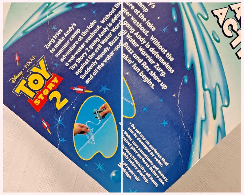 Peut inclure: Jeu d'eau Toy Story 2 avec Woody, Buzz l'&Eacute;clair et Rex. La bo&icirc;te bleue et blanche pr&eacute;sente une image des personnages jouant dans un cours d'eau bleu. Le texte sur la bo&icirc;te indique "Toy Story 2 Water Action".