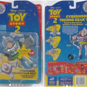 May include: Toy Story 2 action figure of Buzz Lightyear in a silver and green techno gear suit. The figure has a deep-space hook firing action. The packaging is blue and yellow with the words "Cyberhook Techno Gear Buzz" and "Ready to take care of business - in any galaxy!"