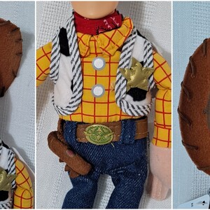 May include: A plush toy of Woody from the Toy Story franchise. Woody is wearing his signature brown cowboy hat, red bandana, yellow and red plaid shirt, white vest with black stripes, blue jeans, and a brown belt with a sheriff's star buckle. He is holding a brown holster with a brown gun inside.