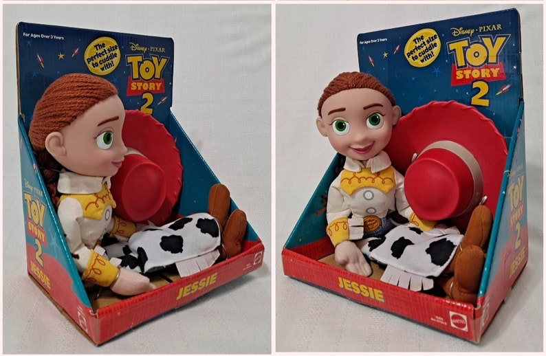 K&ouml;nnte beinhalten: Ein Pl&uuml;schtier von Jessie aus Toy Story 2, in ihrem charakteristischen Cowgirl-Outfit, mit einem roten Hut und braunen Stiefeln. Das Spielzeug ist in einer bunten Schachtel mit dem Toy Story 2-Logo verpackt.