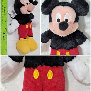 Op de afbeelding: Een pluche Mickey Mouse speelgoed met zwarte vacht, een rode broek en gele schoenen. Het speelgoed heeft een vriendelijke uitdrukking met grote zwarte ogen en een brede glimlach.