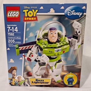 May include: A LEGO Toy Story Construct-a-Buzz set featuring Buzz Lightyear. The box shows Buzz in his green and white spacesuit, with the Disney Pixar and LEGO logos. The set is for ages 7-14 and contains 205 pieces.