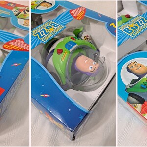 May include: A toy Buzz Lightyear action figure from the Disney Pixar Toy Story 2 movie. The figure is in a plastic spaceship with a clear plastic bubble helmet. The packaging is blue and white with the Toy Story 2 logo and Buzz Lightyear's name.