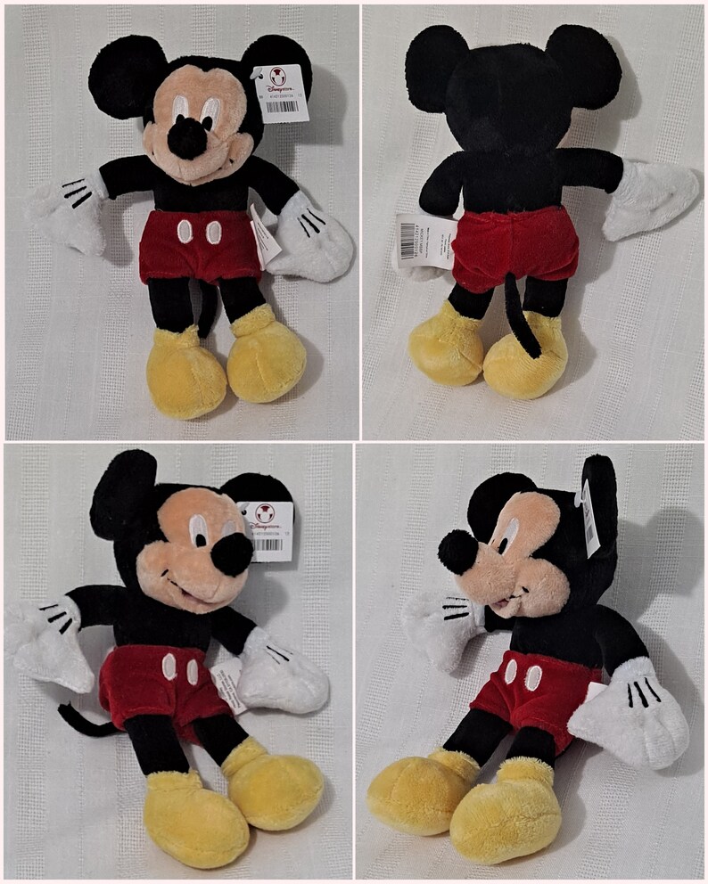 May include: A plush Mickey Mouse toy with black fur, red shorts, and yellow shoes. The toy is sitting on a white surface.